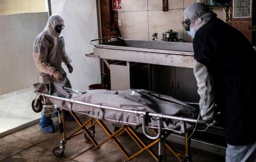 Mortuary workers move the body of a COVID-19 victim at a crematorium in Cuautitlan Izcalli, Mexico State