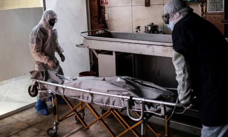 Mortuary workers move the body of a COVID-19 victim at a crematorium in Cuautitlan Izcalli, Mexico State