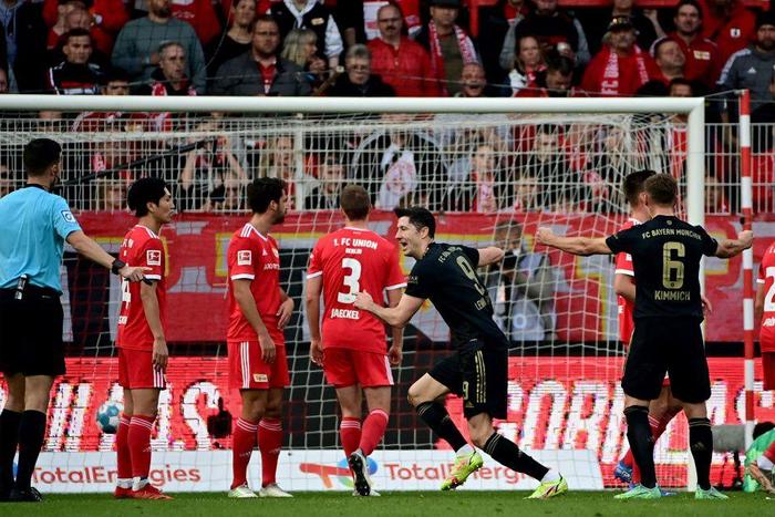 Bayern Munich striker Robert Lewandowski (C) celebrates after scoring from a free-kick at Union Berlin on Saturday
