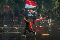 A protester carries Indonesia's national flag and a pirate flag from the Japanese anime One Piece during a protest in front of the governor's residence in Surabaya on August 29. Juni Kriswanto/AFP/Getty Images