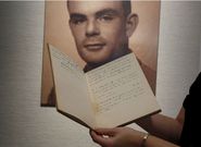 Notebook of Alan Turing is displayed in front of a photo of him. Picture: REUTERS/Bobby Yip