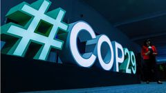 A woman passes by a #COP29 sign during the United Nations climate change conference COP29 in Baku. REUTERS/Maxim Shemetov