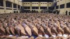 Inmates are lined up during a security operation under the watch of police at Izalco prison in San Salvador, El Salvador, on April 25, 2020. © 2020 El Salvador presidential press office via AP