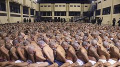 Inmates are lined up during a security operation under the watch of police at Izalco prison in San Salvador, El Salvador, on April 25, 2020. © 2020 El Salvador presidential press office via AP