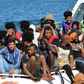 Migrants from Tunisia and Libya arrive onboard of an Italian Coast Guard boat on the Italian island of Lampedusa on August 1