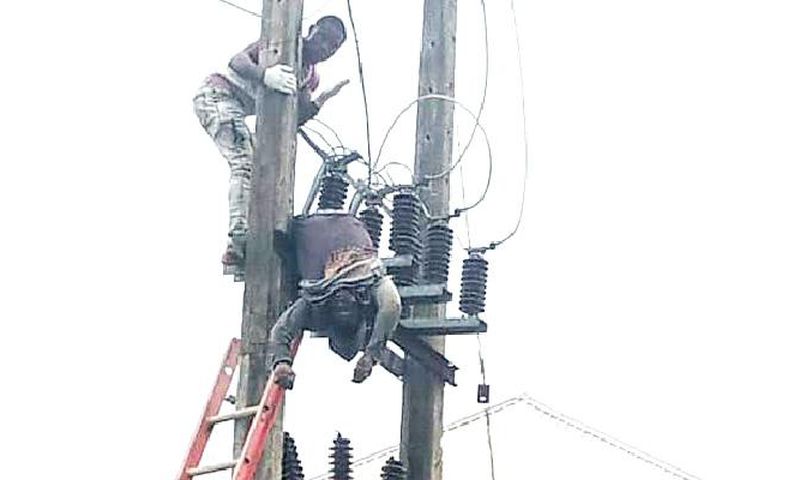 The lifeless body of the suspect was seen dangling on the high-tension pole [Punch]