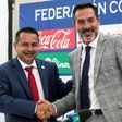 Gustavo Matosas (R) shakes hands with the president of the Costa Rica football federation, Rodolfo Villalobos