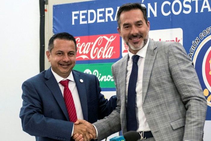 Gustavo Matosas (R) shakes hands with the president of the Costa Rica football federation, Rodolfo Villalobos