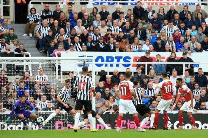 Mesut Ozil (second right) scores Arsenal's second goal in a 2-1 win away to Newcastle in the English Premier League on Saturday