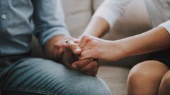 Close up. Man and woman hold hands tightly.