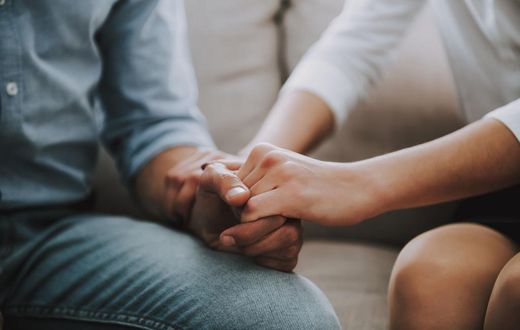 Close up. Man and woman hold hands tightly.