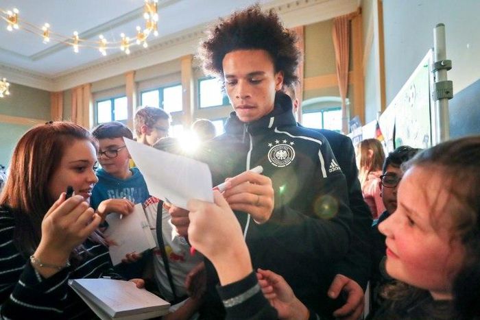 Manchester City winger Leroy Sane (C) signs autographs after Germany's stars held a press conference at a school in Leipzig on Tuesday in which school children were also allowed to ask questions ahead of the friendly against Russia on Thursday.