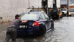 A man pushes a car through the flooded streets of Red Hook in Brooklyn on September 29, 2023.Spencer Platt/Getty Images