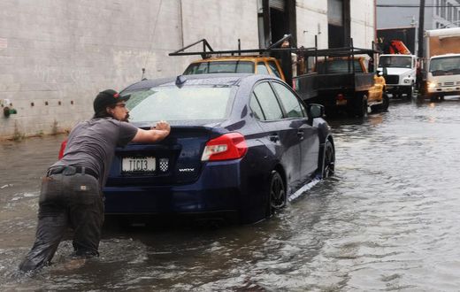 A man pushes a car through the flooded streets of Red Hook in Brooklyn on September 29, 2023.Spencer Platt/Getty Images