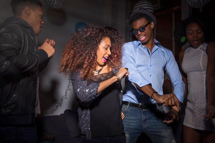 Young man and woman dancing at house party - stock photo