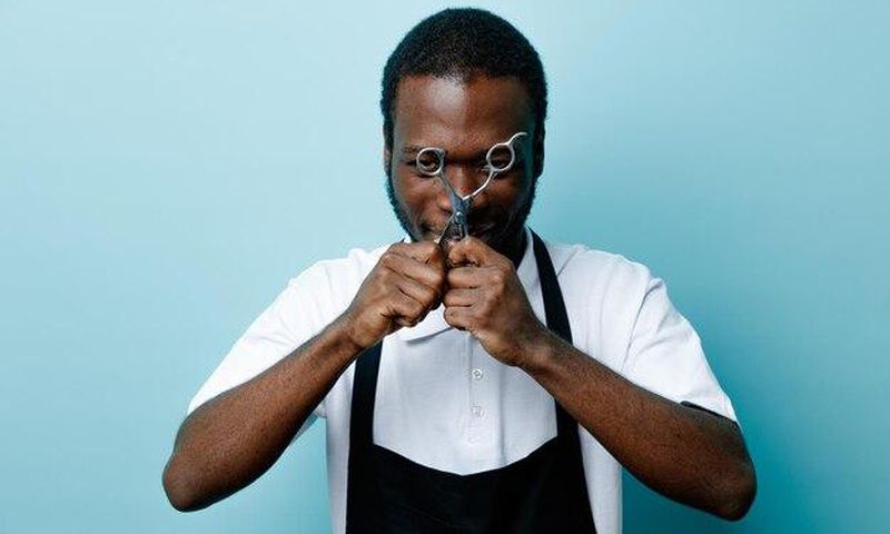 Black man with scissors [Freepik]