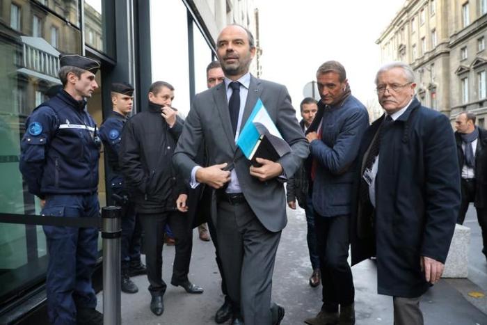 French Prime Minister Edouard Philippe (C) arrives to announce the suspension of fuel tax increases for six months after weeks of "yellow vest" popular protests