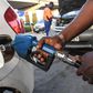 A pump attendant fills a car with fuel at the OlA petrol station, following country wide price hikes on March 15, 2022, in Nairobi. (Photo by SIMON MAINA/AFP via Getty Images)