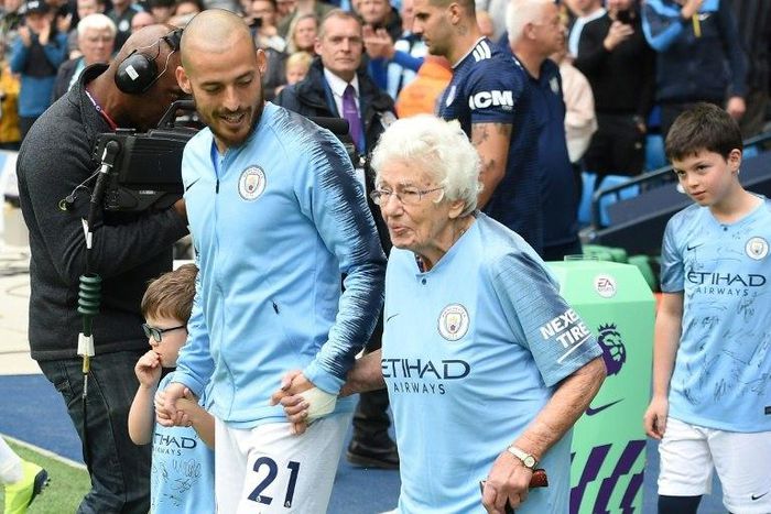 Vera Cohen, a 102-year-old mascot, leads out Manchester City together with David Silva before the English Premier League champions' match at home to Fulham on Saturday