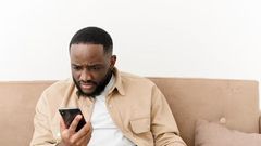 Black man angry at phone (image used for illustration) [Freepik]