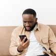 Black man angry at phone (image used for illustration) [Freepik]