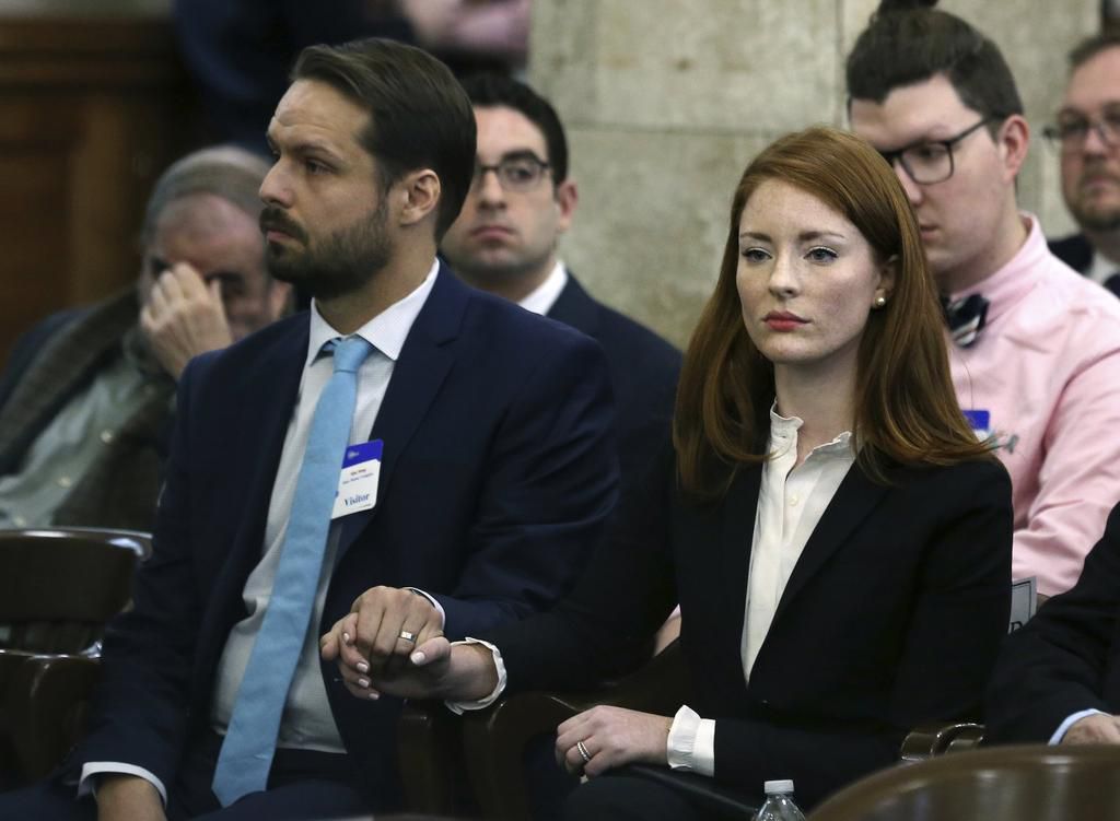 Katie Brennan, the chief of staff at the New Jersey Housing and Mortgage Finance Agency, holds hands with her husband Travis Miles as she waits to testify before the Select Oversight Committee at the Statehouse