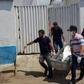 Forensic experts carry a corpse to be transported to the morgue after an attempted bank robbery in Milagres, Ceara state, Brazil
