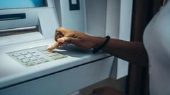 Black woman at an ATM [Shutterstock]