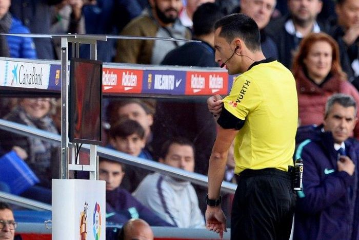 Spanish referee Sanchez Martinez checks the VAR screen before signaling a penalty kick against Real Madrid