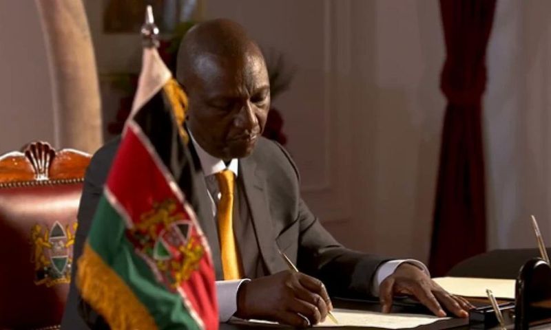 President William Ruto signs a document at State House