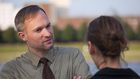 man woman talking on street interview