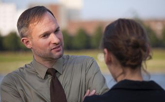 man woman talking on street interview