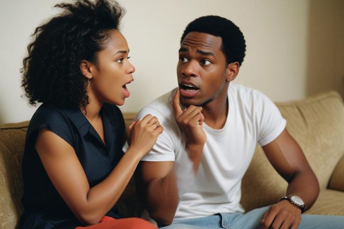 An AI-generated photo of a black couple arguing. They're sitting on a couch