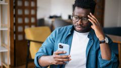 A man looking at his phone worried