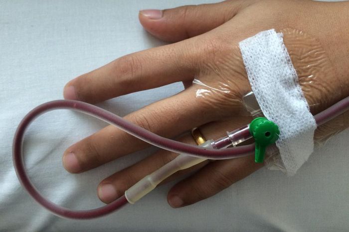 A stock image of a person receiving a blood transfusion. People with hemophilia B receive regular infusions of clotting factor IX to treat their condition.