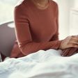 A woman holds a patients hand at a hospital.shapecharge/Getty Images