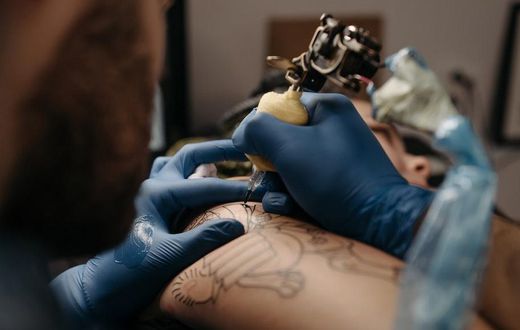 Tattoo artist tattooing a client's arm [Photo: Pavel Danilyuk]