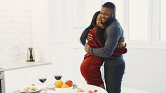 Man and woman hugging and Valentine dinner with wine on table [Image Credit: Gustavo Fring]