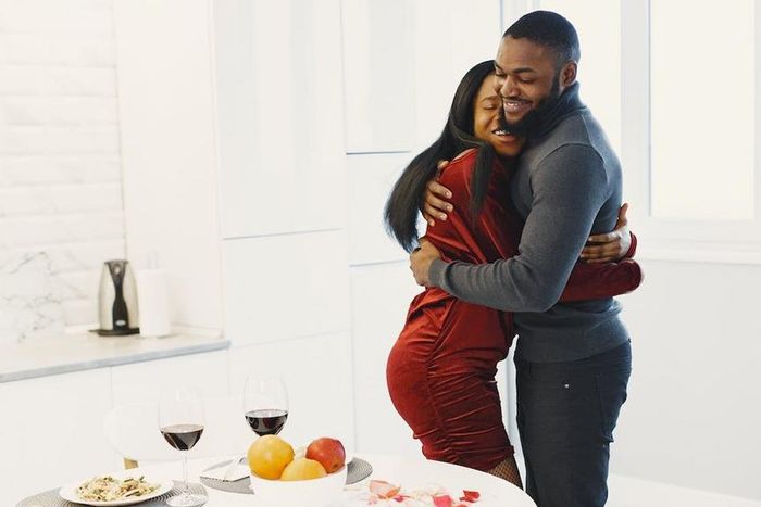 Man and woman hugging and Valentine dinner with wine on table [Image Credit: Gustavo Fring]