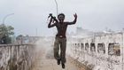 Joseph Duo, a Liberian militia commander loyal to the government, exults after firing a rocket-propelled grenade at rebel forces at a key strategic bridge July 20, 2003 in Monrovia, Liberia. Government forces succeeded in forcing back rebel forces in f...