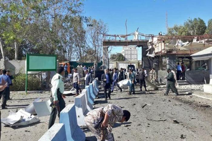 Iranian police survey the aftermath of a suicide car bombing which killed at least two people and wounded many more outside police headquarters in the southeastern port city of Chabahar