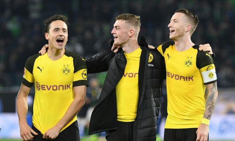 Borussia Dortmund midfielders Thomas Delaney (L), Jacob Bruun Larsen (C) and Marco Reus (R) celebrate Saturday's 1-0 win at Wolfsburg - a new club record of 15 games unbeaten - ahead of Tuesday's tough Champions League game away to Atletico Madrid.