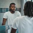Black man looking in the mirror [iStock]
