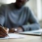 A Black person writing [iStock]