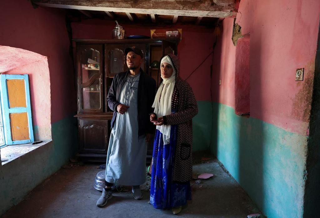 Groom Mohammed Boudad stands with his wife, Habiba Ajdir, inside their house that was damaged in the aftermath of the 6.8 magnitude earthquake, in Kettou village, Morocco September 12, 2023. REUTERS/Emilie Madi