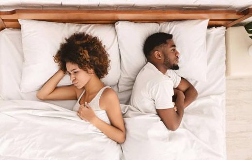 Frustrated Black couple in bed [iStock]