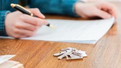 A stock photo shows a person signing a mortgage contract.Getty Images