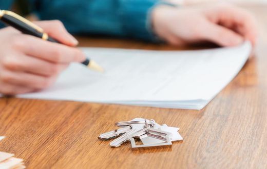 A stock photo shows a person signing a mortgage contract.Getty Images