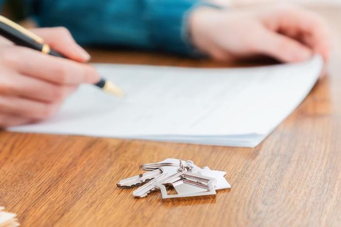 A stock photo shows a person signing a mortgage contract.Getty Images