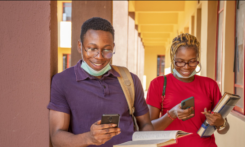 Students pressing their phones [Techpoint Africa]